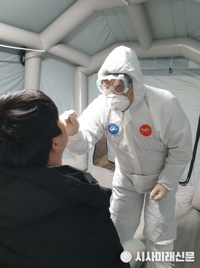 보건소 관계자가 선별진료소에서 검체 채취를 시연하는 모습