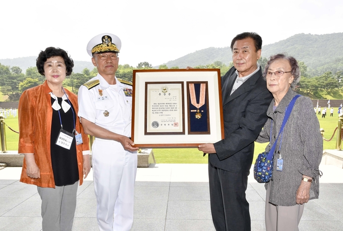 6월 16일 계룡대 대연병장에서 열린 '6.25전쟁 무공훈장 서훈식'에서 부석종 해군참모총장이 고 양한표 소령의 유가족들에게 무공훈장을 전달하고 있다.