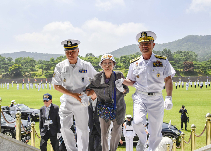 6월 16일 계룡대 대연병장에서 열린 '6.25전쟁 무공훈장 서훈식'에서 부석종 해군참모총장이 고 양한표 소령의 부인 정정애 여사를 부축해 행사장으로 입장하고 있다.