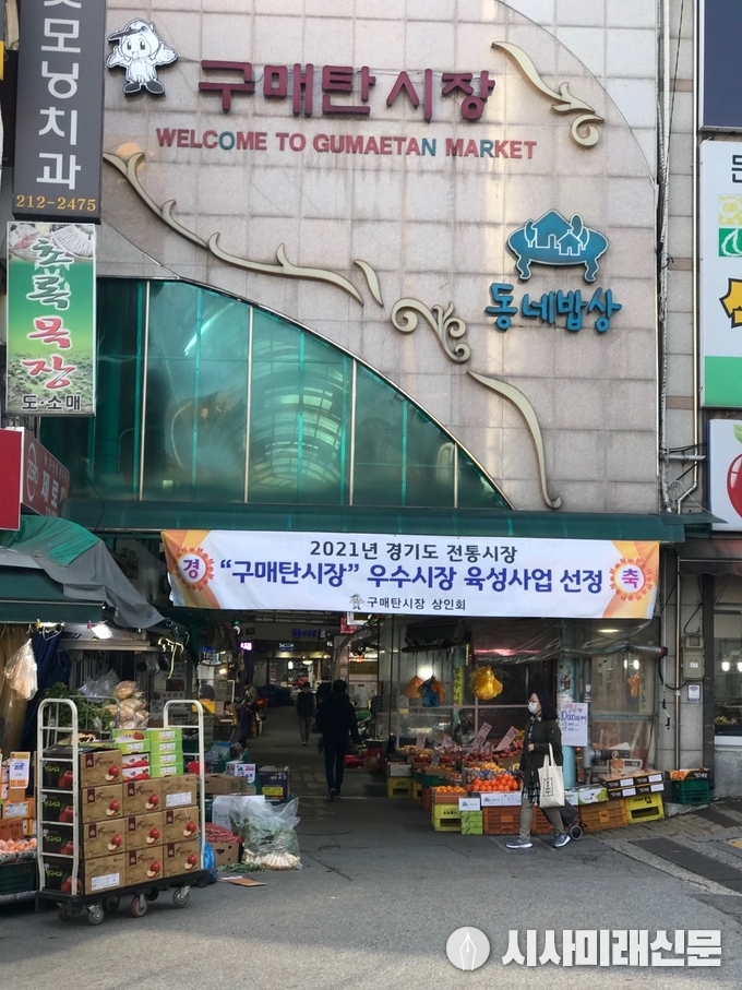 구매탄시장 입구에 우수시장 육성사업 선정을 축하하는 상인회의 현수막이 걸려 있는 모습.