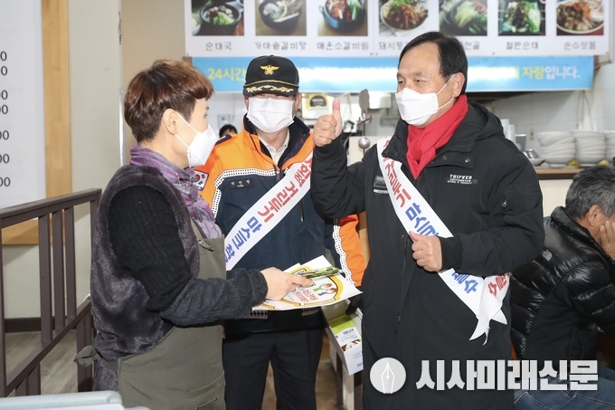 천안시, 경찰서, 교육청, 자생단체 등이 3일 수능 이후 코로나19 확산 방지 및 사회적 거리두기 2단계 격상에 따른 음식점 등 밀집지역 코로나19 방역 준수사항 일제 합동 점검에 나섰다. 박상돈 천안시장이 두정동 점검 현장에서 코로나19 방역수칙 홍보물을 상인들에게 배부하고 있다.