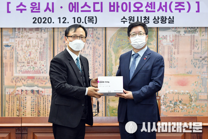 신속항원검사 키트 기증 후 염태영 시장(오른쪽)과 이효근 SD 바이오센서 대표가 함께하고 있다.