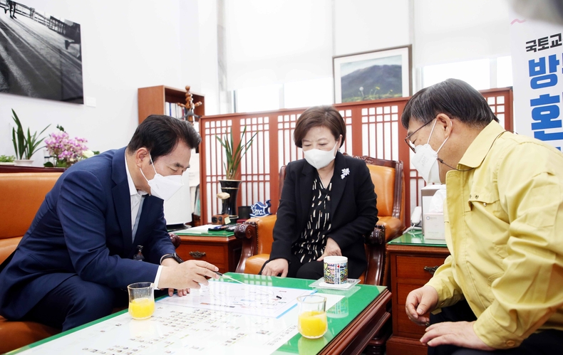 백군기 용인시장이 진선미 국토교통위원장을 만나 신동헌 광주시장과 함께 건의문을 전달하고 있다.