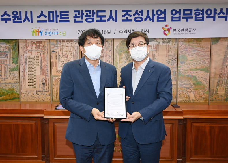 염태영 시장(오른쪽)과 안영배 사장이 협약서에 서명한 후 기념촬영을 하고 있다.