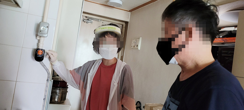 기흥구보건소 치매안심센터 관계자가 치매 어르신에게 타이머 콕 사용법을 안내하고 있다
