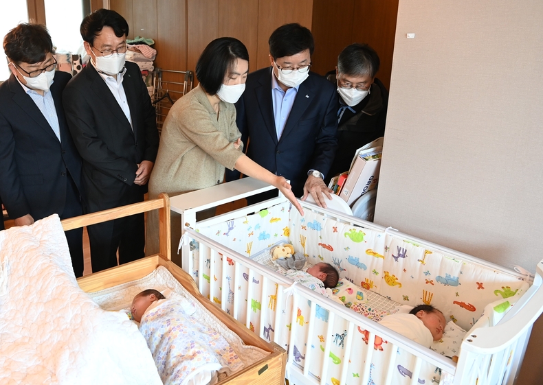 염태영 시장(오른쪽 2번째)이 홍은미(오른쪽 3번째)씨의 세쌍둥이를 바라보고 있다.