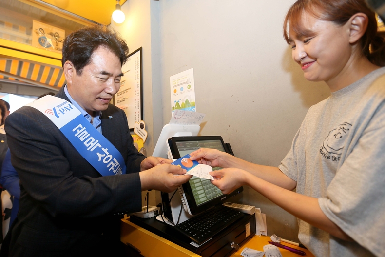 백군기 시장이 용인중앙시장 내 점포에서 용인와이페이를 사용하고 있는 모습