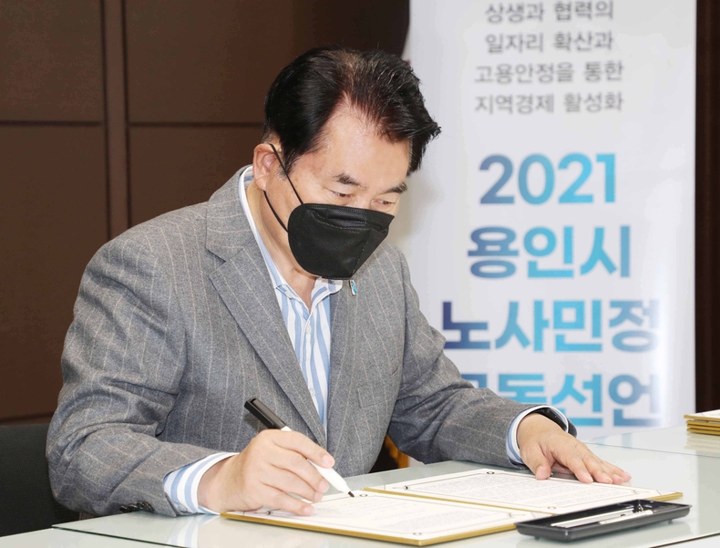 28일 백군기 용인시장(용인시노사민정협의회 위원장)이 '용인시 노사민정 공동선언' 협약서에 서명을 하고 있다.