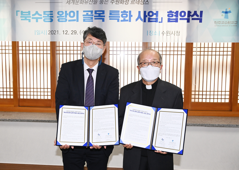 유문종 수원시 제2부시장(왼쪽)과 천주교 수원교구 사무처장 양태영 신부가 협약식 후 기념촬영을 하고 있다.