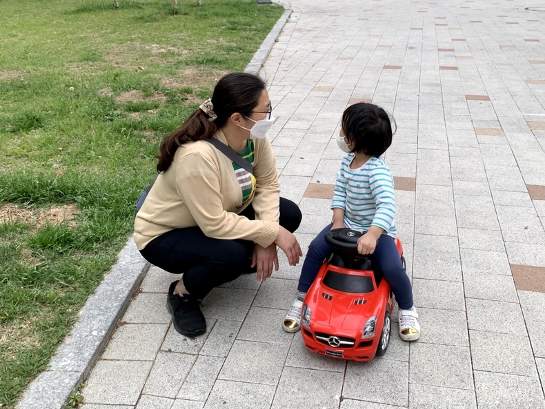 영아전담 돌보미 이지영씨가 서비스 대상 아동과 집앞 놀이터에서 그네를 밀어주는 등 바깥놀이를 즐기고 있다
