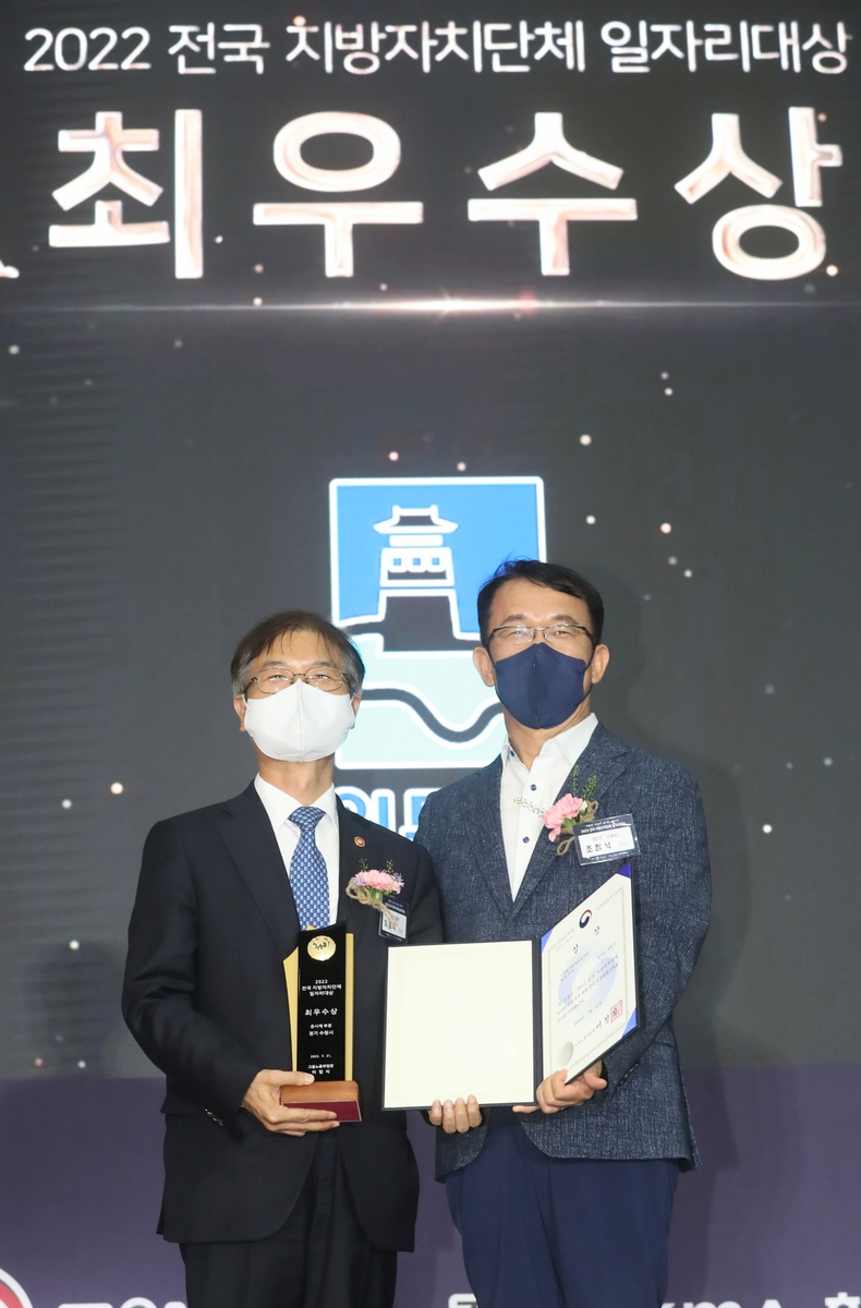 조청식 수원시 제1부시장(오른쪽)이 최우수상을 받고, 이정식 고용노동부 장관과 함께하고 있다.