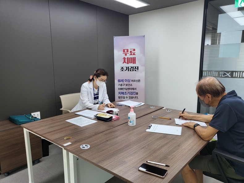 기흥구보건소 관계자가 치매 조기검진을 위해 어르신과 상담하고 있는 모습