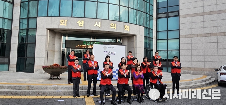 화성시의회 김경희 의장과 시의원들이 의회 정문앞에서 반대 표시를 하고있다.(사진=김은숙 기자)