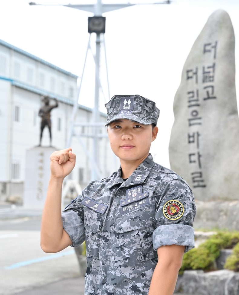 해난구조 기본과정을 수료하고 여군 최초로 심해잠수사(SSU)가 된 문희우 대위(진)이 '더 넓고 더 깊은 바다로' 비석 앞에서 포즈를 취하고 있다.