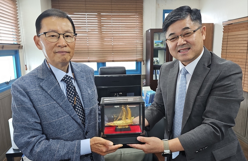 해군대 김성환 총장(해사46기)이 배동용 고문에게 황금 거북선을 증정하고 있다. 