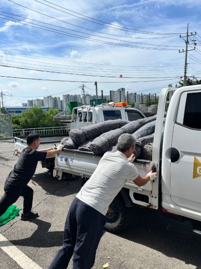 23일 김포시자율방재단 사무국장, 방재단원, 읍면동 재난담당자, 환경반이 2025년 여름철 자연재난 대비 수방자재 수령하는 장면이다.