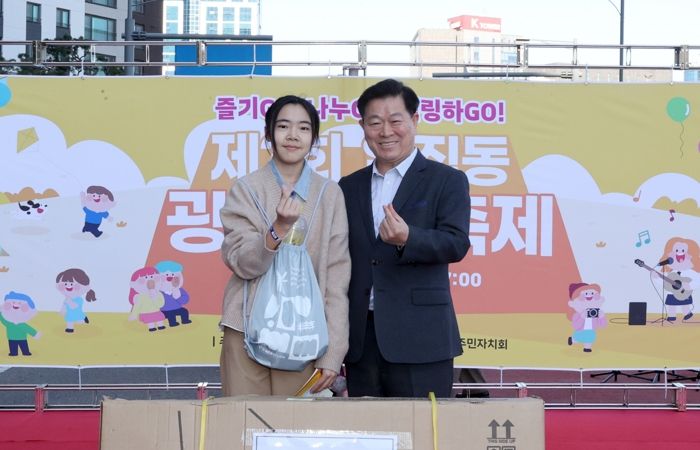 박승원 광명시장이 지난 1일 일직동 새빛공원로 차 없는 거리에서 열린 ‘제3회 일직동 광명새빛축제’에 참석해 상품을 전달하고 기념사진을 촬영하고 있다,