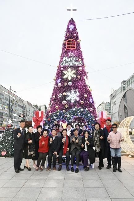 이민근 안산시장(앞줄 오른쪽 다섯번째)이 지난 9일 안산문화광장 썬큰광장에서 점등식을 마치고 성탄트리 앞에서 기념촬영을 하고 있다.