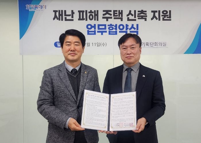 화성특례시 정연송 주택국장과 화성·오산지역건축사회 전영식 회장이 재난 피해 주택 신축 지원 업무협약을 체결하고 협약서를 들고 사진촬영하고 있다.